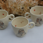 Tasse pour enfant en faïence blanche, décorée de chaque côté par un chiot et un chaton , des petits coeurs et os à l'intérieur