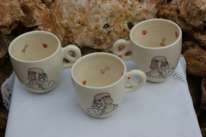 Tasse pour enfant en faïence blanche, décorée de chaque côté par un chiot et un chaton , des petits coeurs et os à l'intérieur